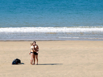 Una pareja disfruta del sol en la playa de La Concha de San Sebastián Una pareja disfruta del sol en la playa de La Concha de San Sebastián